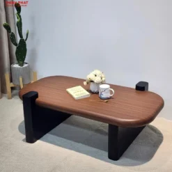 Bàn trà oval gỗ nâu chân đen tối giản đặt cạnh sofa, phù hợp tham khảo trước khi chọn mua